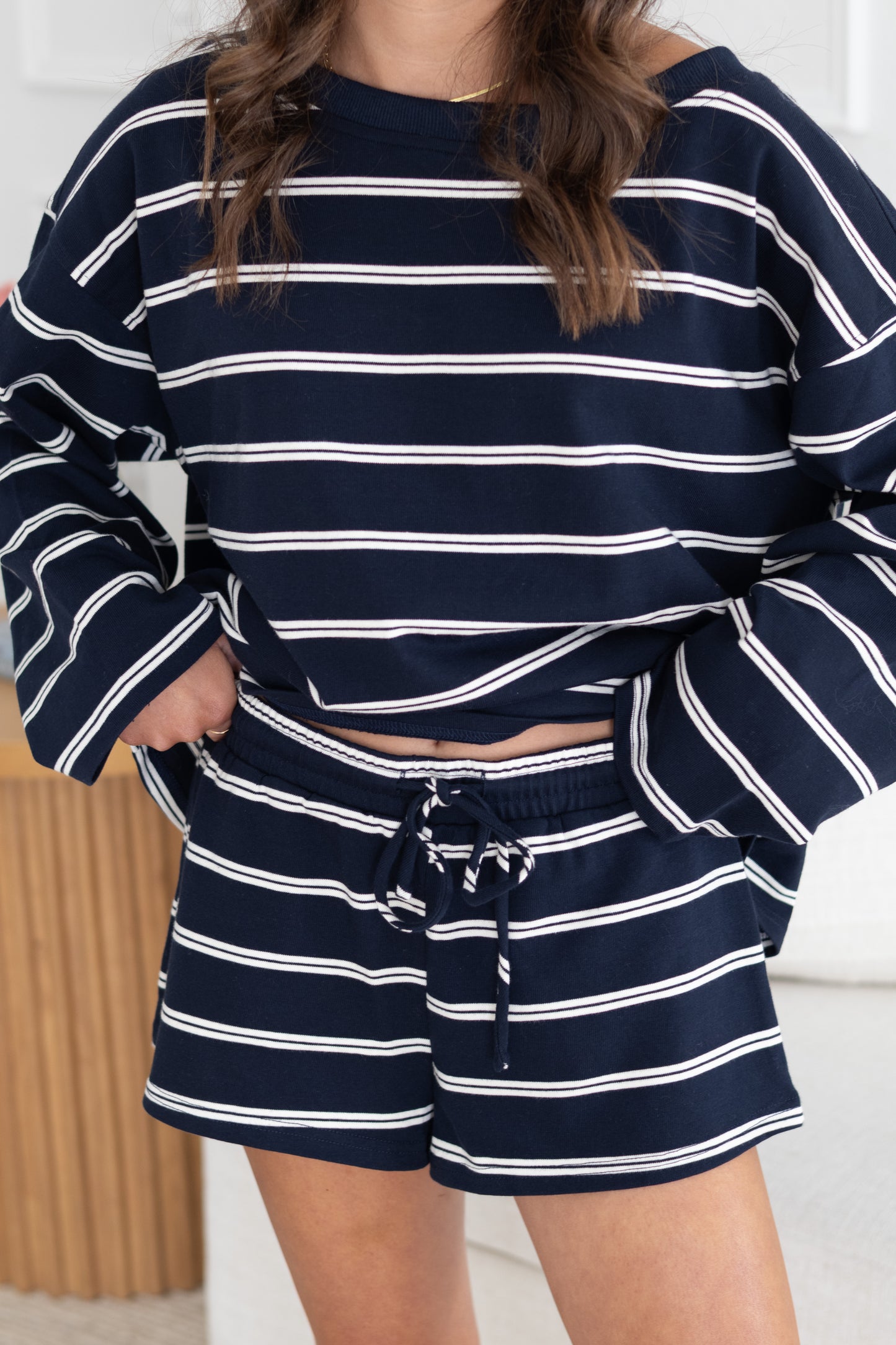 Person wearing a navy and white striped outfit with shorts.