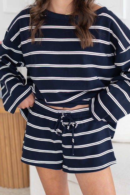 Person wearing a navy and white striped outfit with shorts.