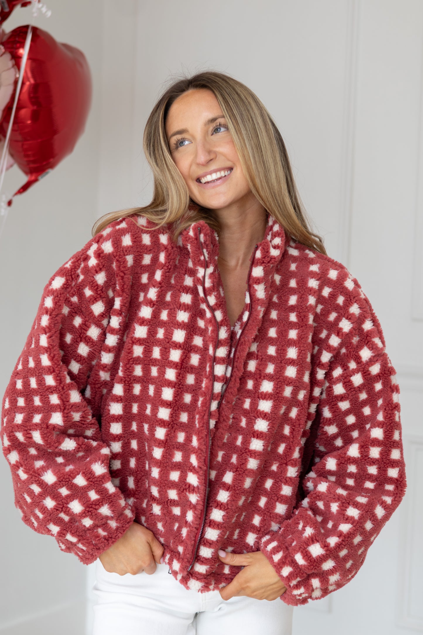 Woman wearing a red and white checkered shirt with a plain background