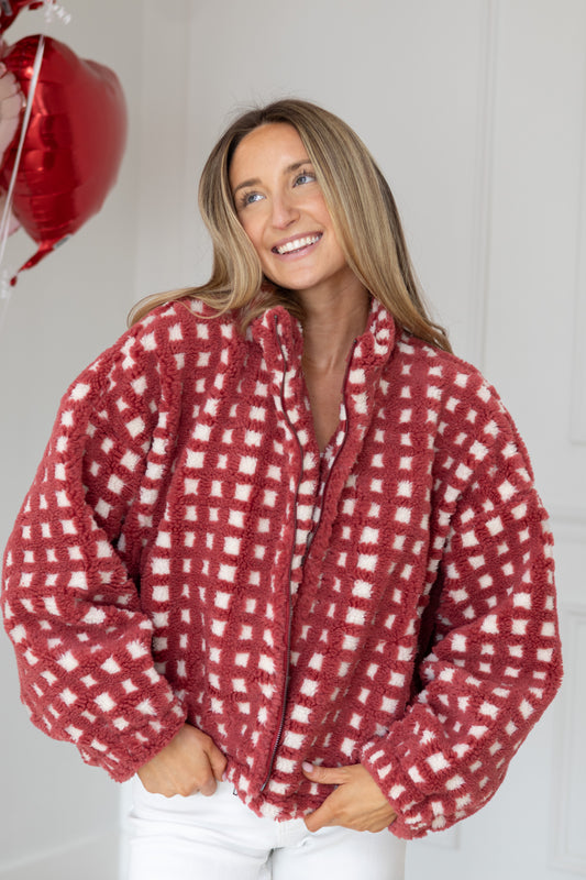 Woman wearing a red and white checkered shirt with a plain background