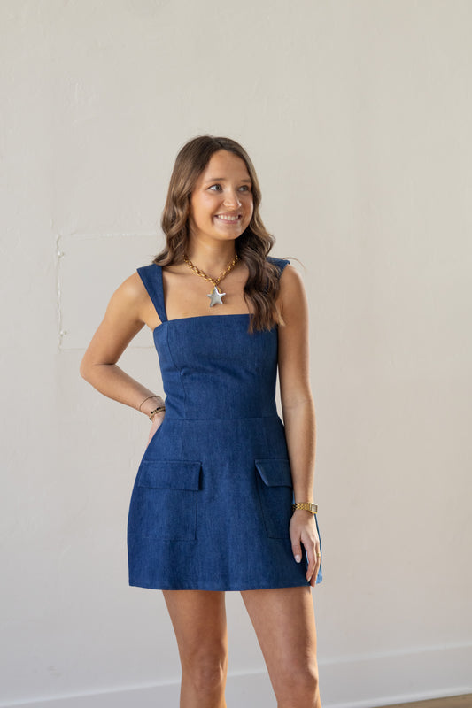 Woman wearing a blue dress against a plain background