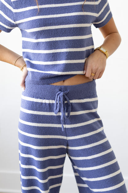 Person wearing a blue and white striped outfit with a plain background