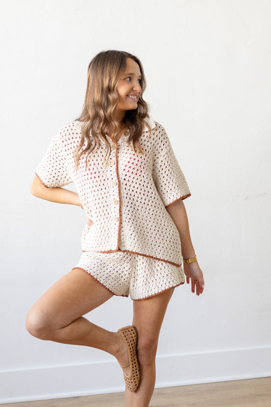 Woman wearing a beige patterned outfit against a white background