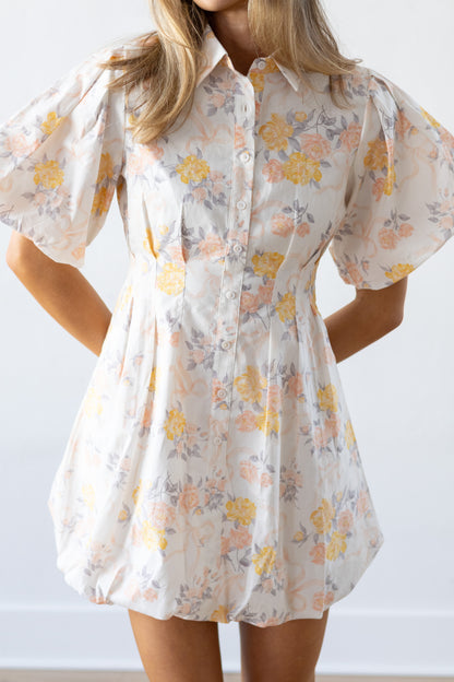 Woman wearing a floral dress with puff sleeves against a white background