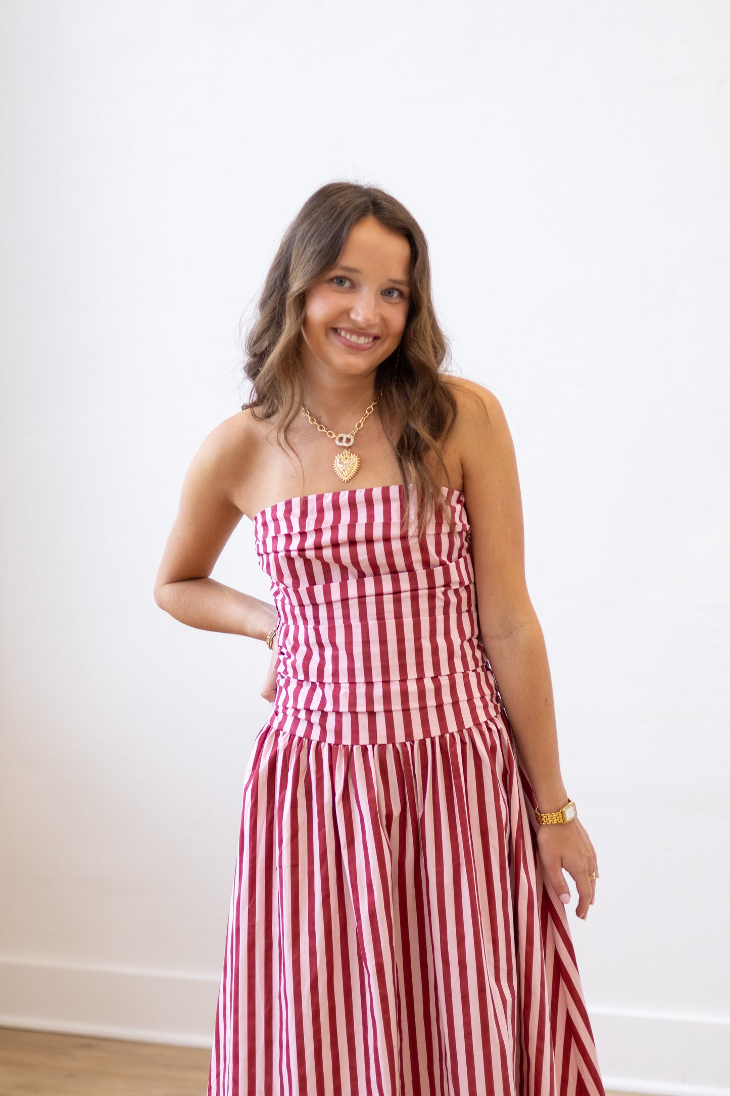 Woman wearing a red and white striped dress against a plain background