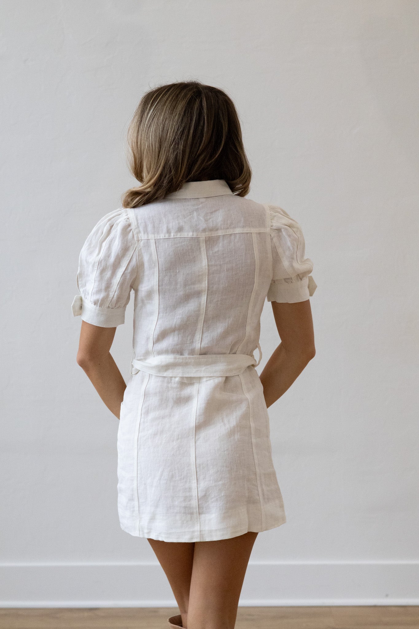 Woman wearing a white dress against a plain background