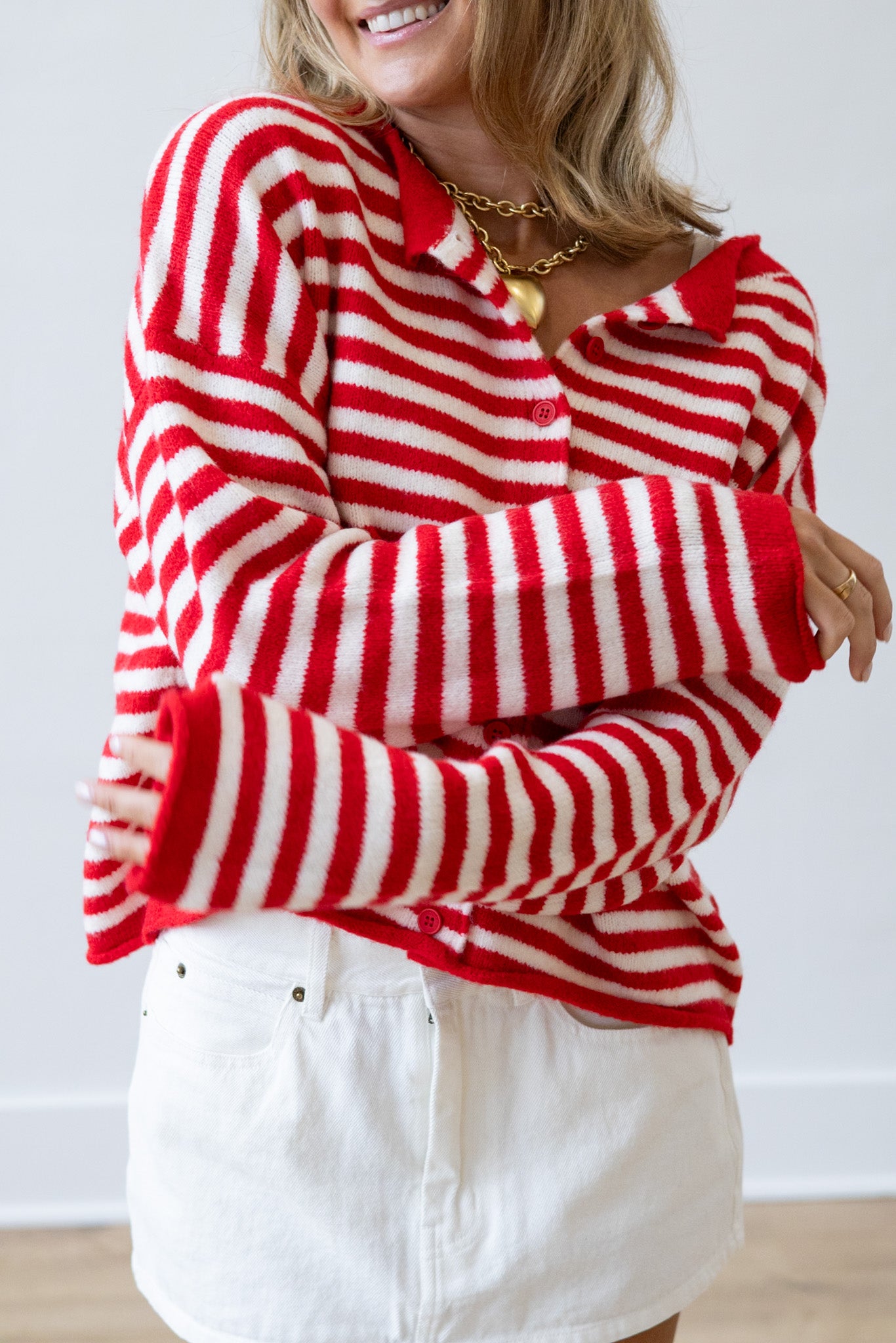 Person wearing a red and white striped sweater with a plain background