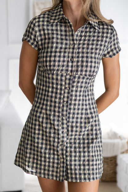 Person wearing a checkered dress with a blurred background
