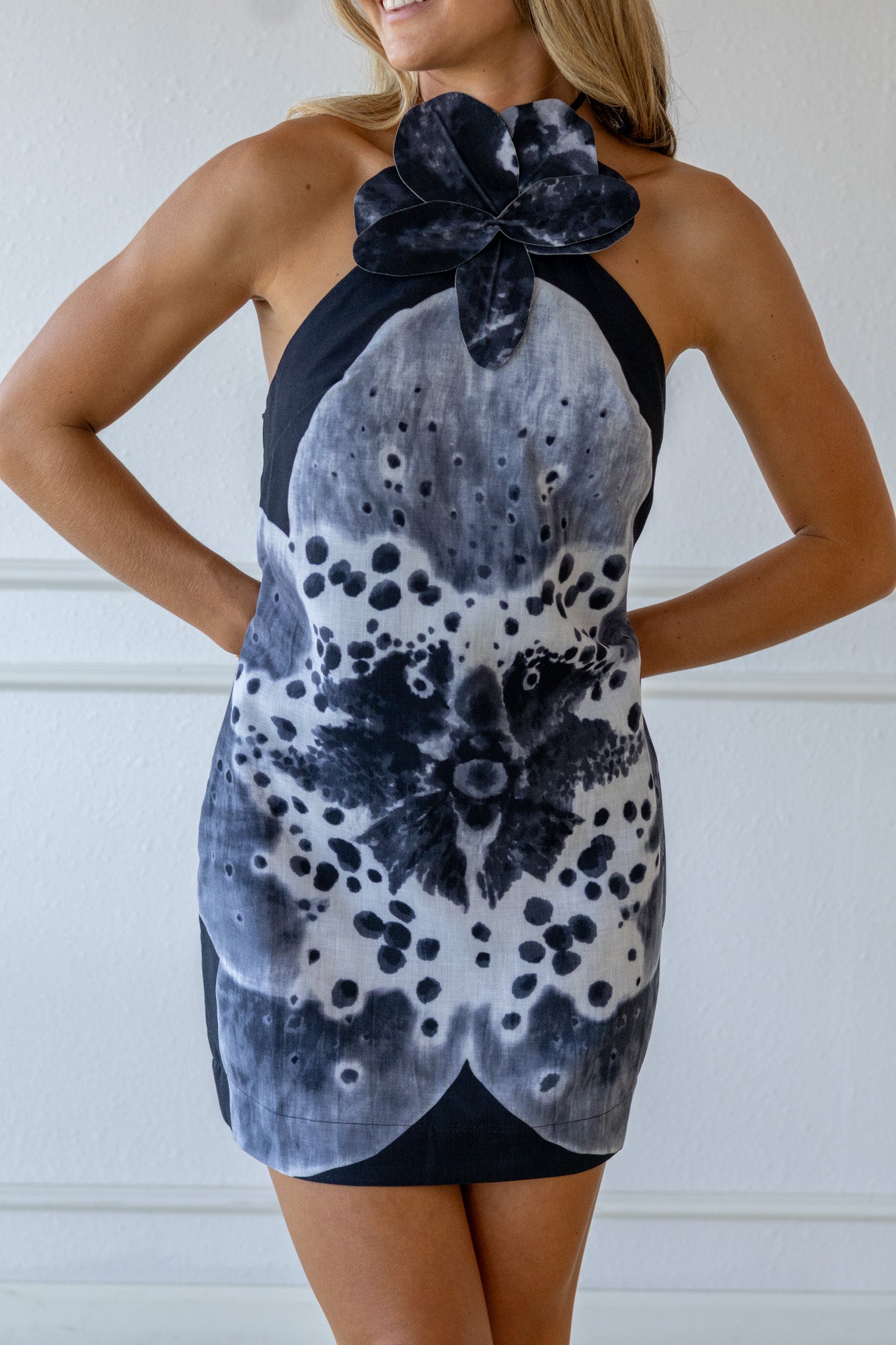 Woman wearing a black and white floral dress against a white background