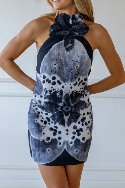 Woman wearing a black and white floral dress against a white background
